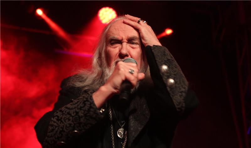 Joachim Witt singt auf der Bühne ins Mikro, im Hintergrund scheint rotes Licht.