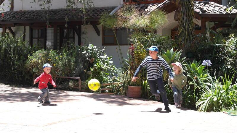 Drei Kinder spielen in Ecuador Fußball.