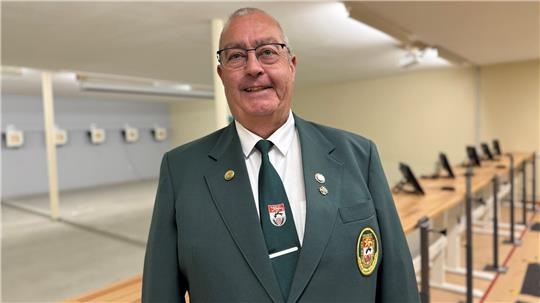 Das Foto zeigt einen Mann vor einem Schießstand.