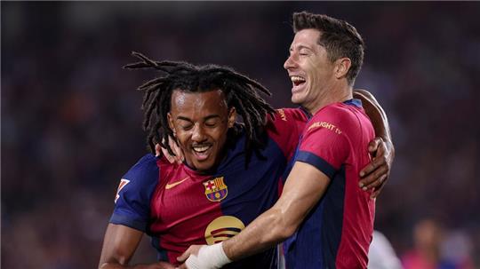 Jubel über das 6.500. Ligator in der Geschichte des FC Barcelona: Torschütze Robert Lewandowski (r) feiert mit Jules Kounde.