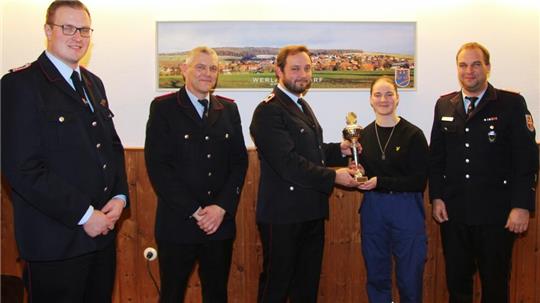 Jugendfeuerwehrwart Jonas Bothe überreicht Linn Brunke den Anwesenheitspokal.