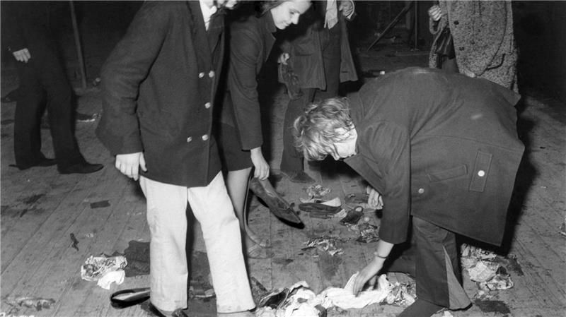 Jugendliche sammeln Schuhe ein, die sie auf die Bühne geworfen haben. (Archivbild)