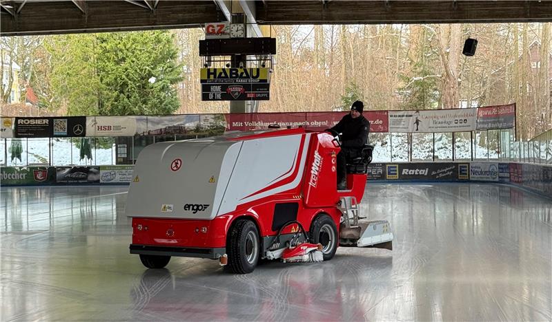 Ein Mann steuert die neue Eismaschine über das Eis im Eisstadion.