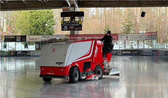 Ein Mann steuert die neue Eismaschine über das Eis im Eisstadion.