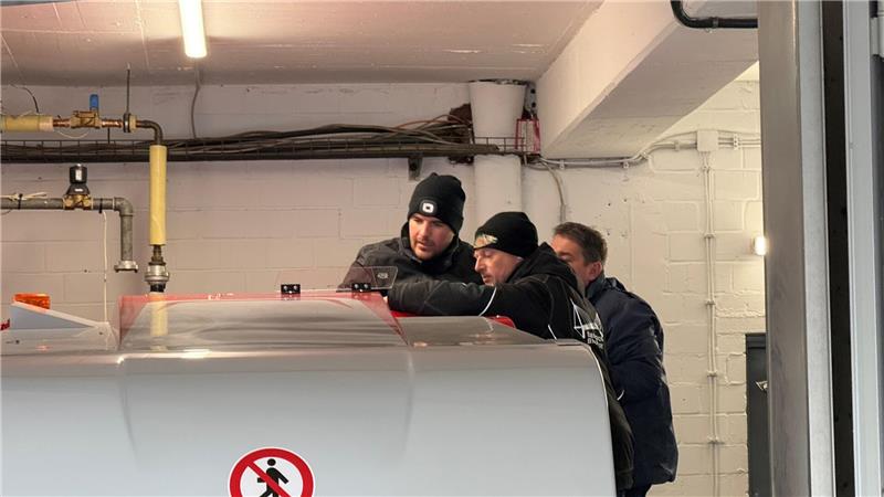 Ein Mann erklärt zwei weiteren etwas.