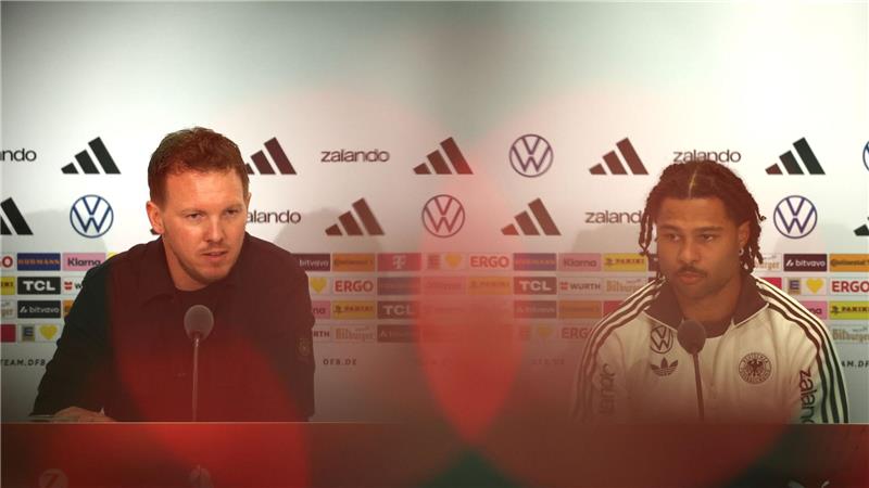 Julian Nagelsmann (l) und Serge Gnabry sprechen bei der DFB-Pressekonferenz.