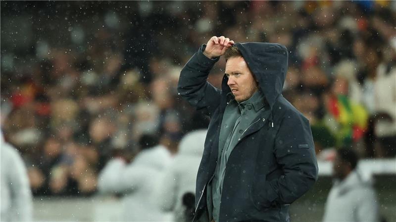 Julian Nagelsmann zieht sich im Regen eine Kapuze über den Kopf.