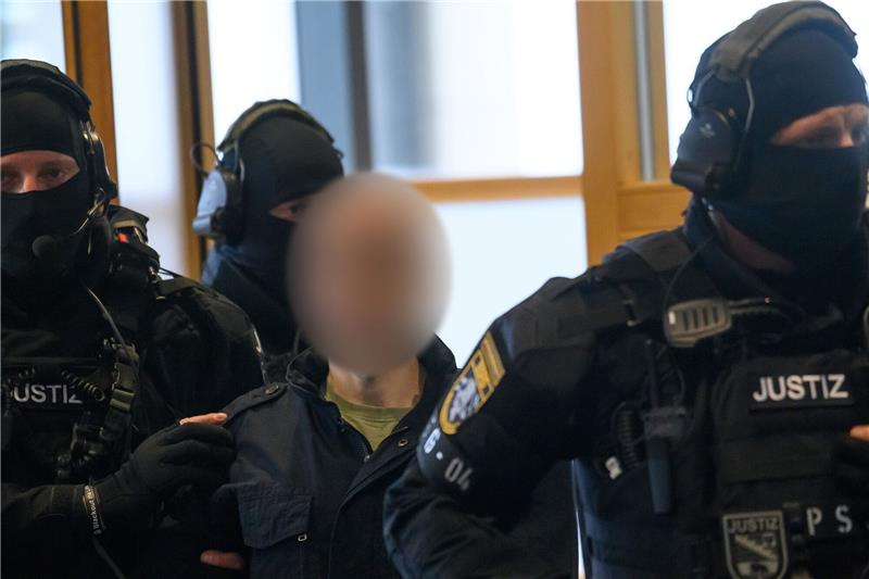 Justitzbeamte führen den Angeklagten in den Gerichtssaal in Magdeburg.
