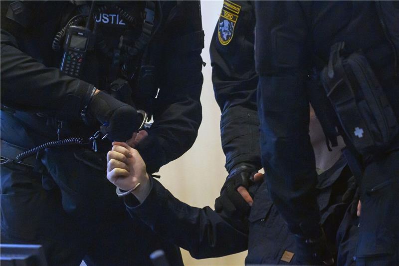 Halle-Attentäter gesteht Geiselnahme in Haft Justitzbeamte nehmen dem Angeklagten Stephan Balliet im Gerichtssaal die Handschellen ab.