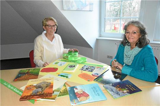 Jutta Noël (li.) und Ines Reinecke sind ein Tandem – sie teilen sich die Begleitung einer Familie. Im Christophorus-Haus sitzen sie gerade an der Vorbereitung des Schaukastens, in dem auf die Angebote am Kinderhospiztag (10. Februar) hingewiesen wird. Foto: Kempfer