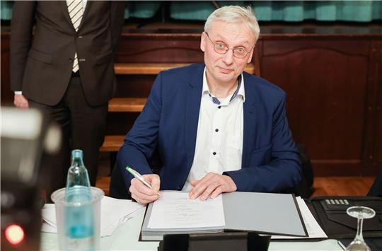 Kai Uwe Evers, der Bürgermeister von Norderwöhrden, unterzeichnet einen Durchführungsvertrag.