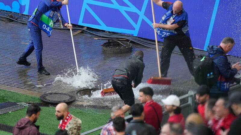 Unwetter in Teilen Deutschlands - Fanzonen betroffen Kampf gegen die Wassermassen: Mitarbeiter sind vor dem Spiel Türkei gegen Georgien im Stadion im Einsatz.
