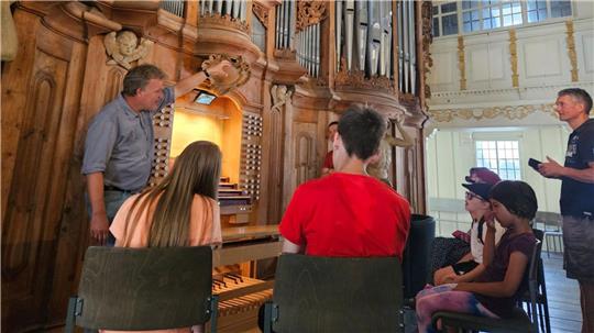 Kantor Arno Janssen führt Jugendliche in die Geheimnisse der Goll-Orgel ein.