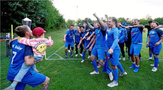 Kapitän André Botta präsentiert seinen Mannschaftskameraden vom VfL Salder III den Pokal der Goslarschen Zeitung.