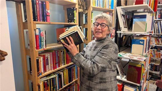 Karin Krömer nimmt Bücher aus ihrem Regal