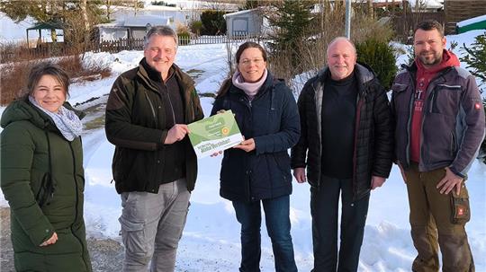 Karin Landers (M.) nimmt als Geschäftsführerin des Campingplatzes Prahljust die Auszeichnung von Nationalparkleiter Roland Pietsch entgegen. Mit bei der Übergabe sind (v.l.) Cordula Dähne-Torkler von der Nationalparkverwaltung, Dieter Lambertz als Mitglied des Nationalpark-Beirates sowie Mario Heilmann, Mitarbeiter des Campingplatzes.