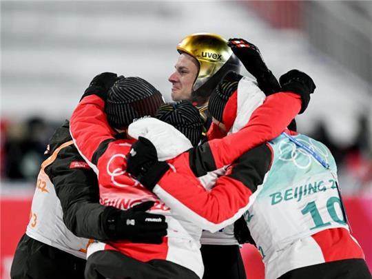 Karl Geiger (hinten) feiert mit seinen Teamgefährten Markus Eisenbichler (l), Constantin Schmid (2.v.l.) und Stephan Leyhe. Foto: Hendrik Schmidt/dpa-Zentralbild/dpa