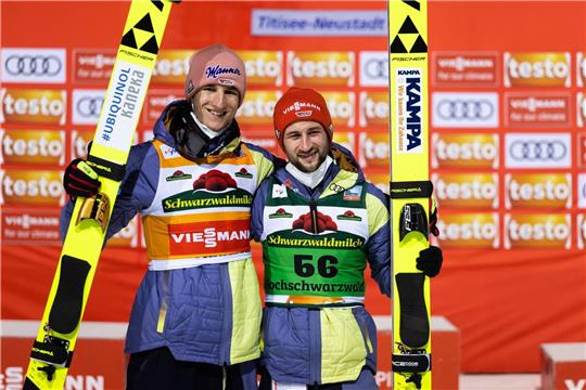 Karl Geiger (l) und Teamkollege Markus Eisenbichler stehen nebeneinander und posieren für die Fotografen.