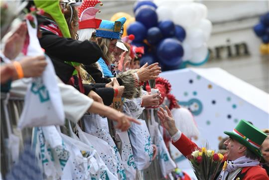Karnevalisten auf dem Wagen verteilen beim Kölner Rosenmontagszug Köln Kamelle und Blumensträuße (Strüßjer) - doch wie umweltfreundlich sind eigentlich die Verpackungen?