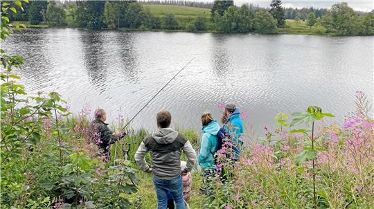 Karpfen-Spezialist Christian Bruns (li.) vom Sportfischerverein Oberharz erklärt den Interessierten am Sumpfteich in Buntenbock, mit welchen Tricks und welchen Ködern die Fische angelockt werden. Foto: Nachtweyh