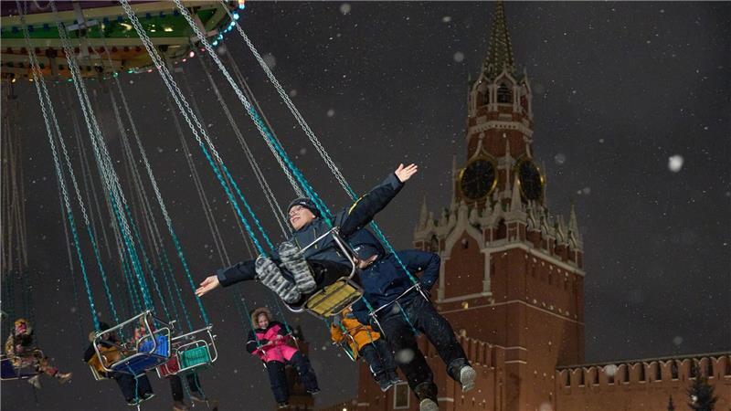 Karussell vor Kremlkulisse: Kinder vergnügen sich auf dem Weihnachtsmarkt am Roten Platz