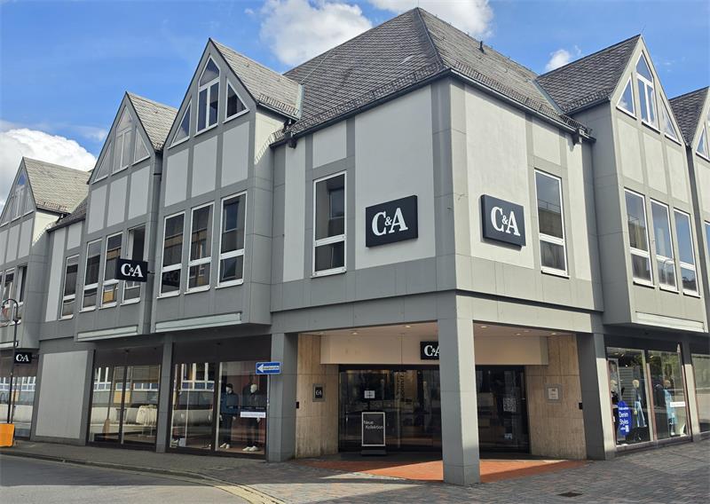Mehrstöckiges Geschäftshaus mit spitz zulaufendem Dach und mehreren C&A-Logos an der Fassade.