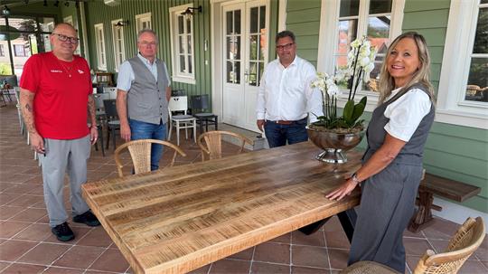 Das Foto zeigt vier Menschen, die an einem Tisch stehen.