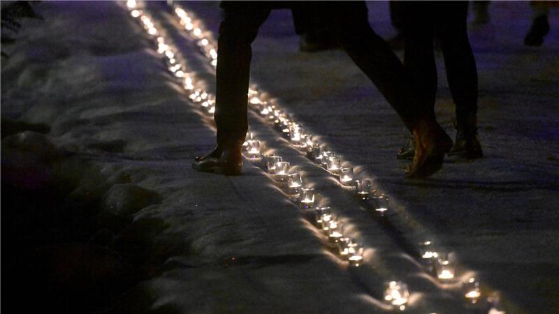 Kerzen in einer symbolischen Loipe erinnern an Laura Dahlmeier. 
