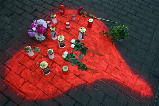 Kerzen und Blumen liegen in einem auf das Pflaster gesprühten roten Herzen in Düsseldorf nach dem mörderischen Brandanschlag.