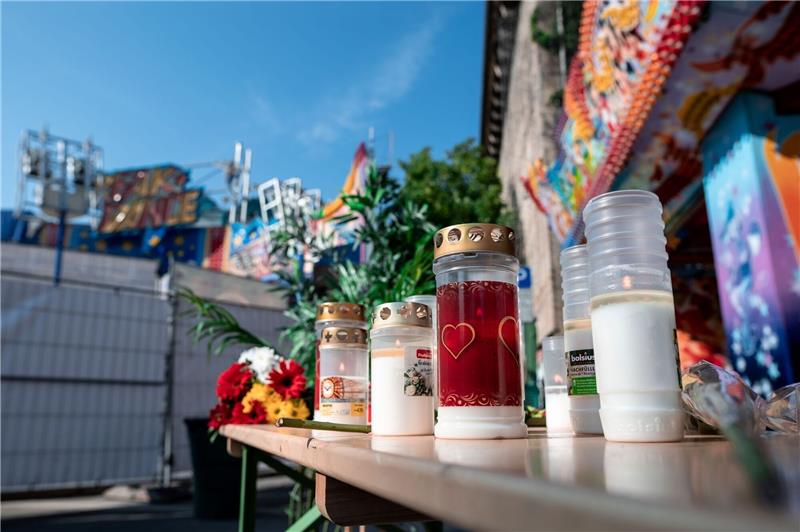 Kerzen und Blumen vor dem Fahrgeschäft «BreakDance» in Oberhausen, auf dem sich der tödliche Unfall ereignete.