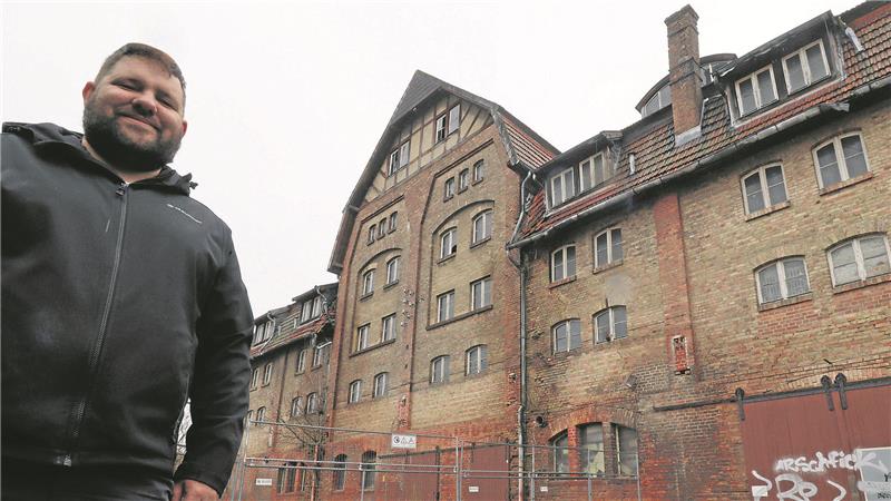 Ein Mann steht vor einem alten Gebäude.