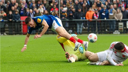 Kiels Adrian Kapralik (l) prallt mit Nürnbergs Jan Reichert zusammen.