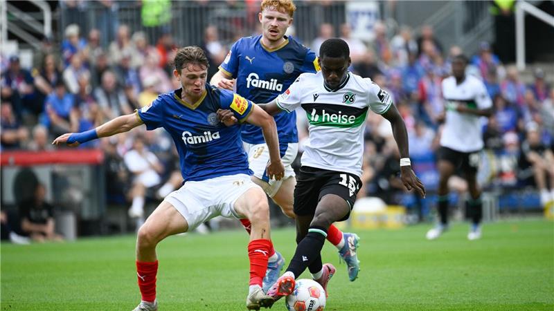 Kiels Magnus Knudsen (l) im Duell mit dem Hannoveraner Noel Aseko.