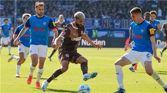 Kiels Marco Komenda (l-r), St. Paulis Elias Saad und Kiels Marko Ivezic kämpfen um den Ball.