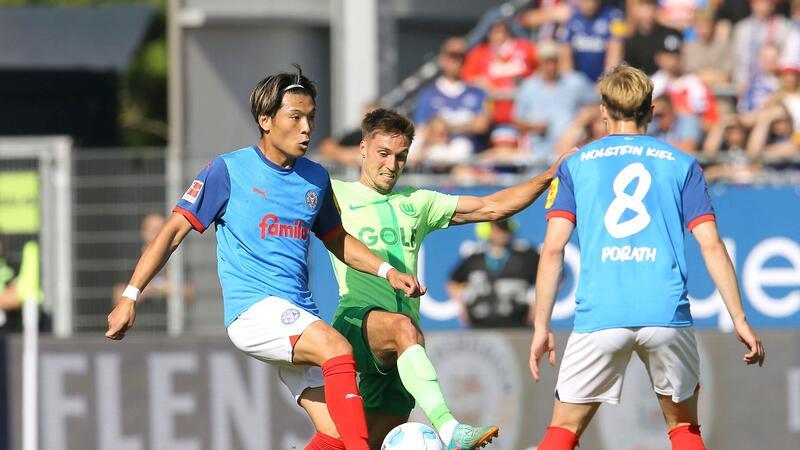 Kiels Shuto Machino (l) und Wolfsburgs Kilian Fischer kämpfen um den Ball.