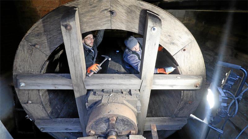 Zwei Männer stehen im Wasserrad.