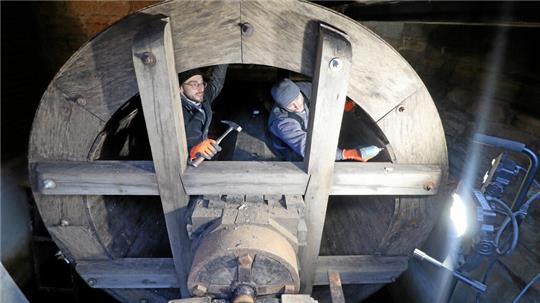 Zwei Männer stehen im Wasserrad.