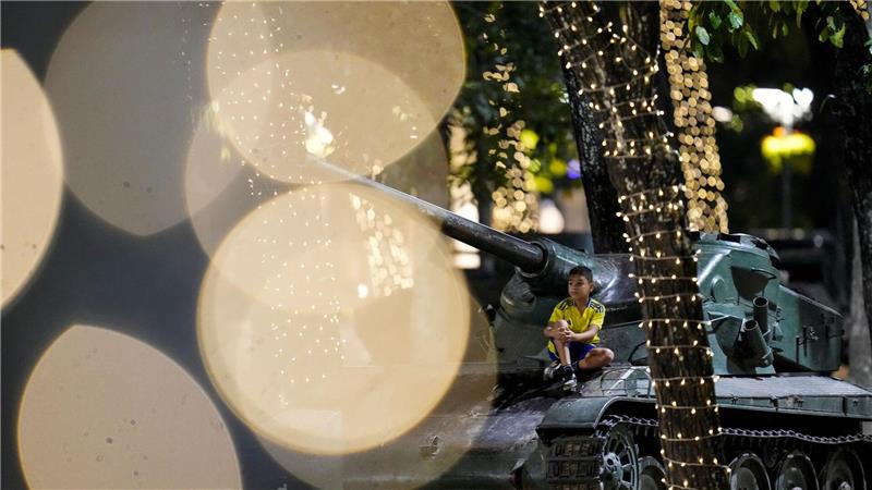 Kind auf gepanzertem Fahrzeug zwischen Lichterglanz und Weihnachten in Caracas