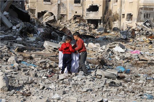 Kinder sammeln Gegenstände in den Trümmern zerstörter Gebäude im Flüchtlingslager Dschabalia am Rande von Gaza-Stadt.
