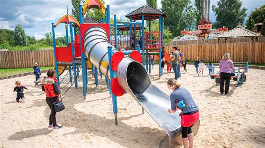 Kinder und Erwachsene auf einem Spielplatz: Experten sind sich sicher, dass die erhöhten Blutbleiwerte von Mädchen und Jungen aus dem Landkreis Goslar ihre Ursache in mit Schwermetall belasteten Böden haben. Sie raten aber davon ab, Kinder aus übertriebener Vorsicht nicht mehr draußen spielen zu lassen.
