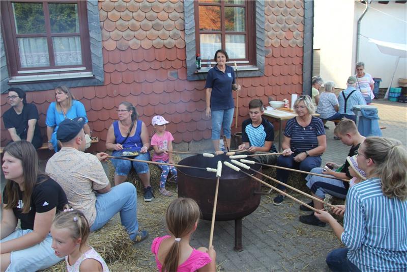 Kinder und Erwachsene bereiten beim Herbstfest Stockbrot zu. Foto: Hohaus