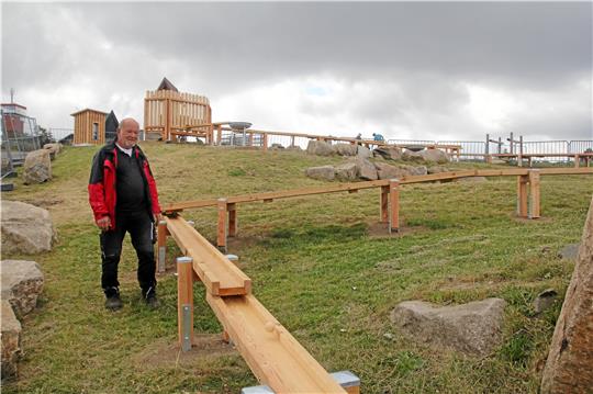 Klaus-Dieter Fischer steht an der Murmelbahn, die er in den vergangenen anderthalb Monaten zusammen mit Peter Rafezeder gefertigt hat. Die Murmeln für die Bahn (rundes Bild) haben einen Durchmesser von 45 Millimetern.  Fotos: Eggers