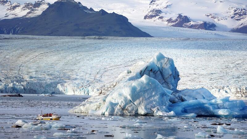 Eishöhlenunglück auf Island - ein Toter und späte Entwarnung Kleines Boot, mächtiges Eis: Touristen fahren auf der Gletscherlagune Jökulsarlon an einem Eisberg vorbei. (Archivbild)