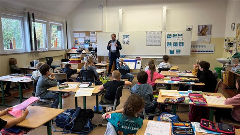 Klimaschutzmanager Frederick Banse erklärt Grundschülern wie die Schnitzeljagd zur Mobilitäswoche abläuft.