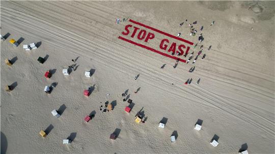 Klimaschutzaktivisten von Fridays for Future schreiben ihre Forderung nach einem Ende der Gasförderung auf den Strand der Insel Borkum. 
