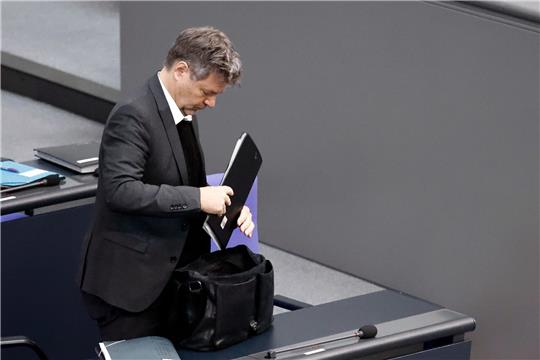 Klimaschutzminister Robert Habeck legt nach der Debatte zum Strompreisbremsengesetz  Akten in die Tasche.