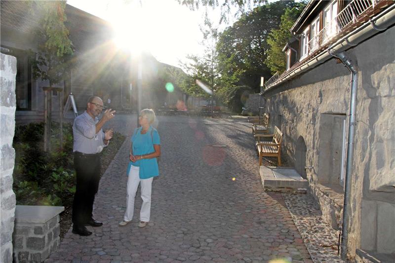 Klostergeschäftsführer Karl-Heinz Purucker mit einer Besucherin. Im Gebäude rechts entsteht ein Infopunkt, die Rezeption befindet sich im Haus links.  Foto: Stade