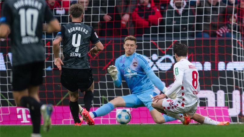 1. FC Köln stürmt auf Aufstiegsplatz: 3:1 gegen Nürnberg Kölns Denis Huseinbasic (r) trifft gegen FCN-Torhüter Jan Reichert (M) zum 3:0.