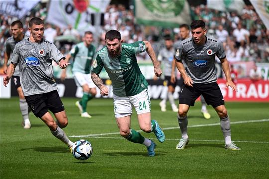 Kölns Niklas May (l) und Bremens Oliver Burke (M) kämpfen um den Ball.