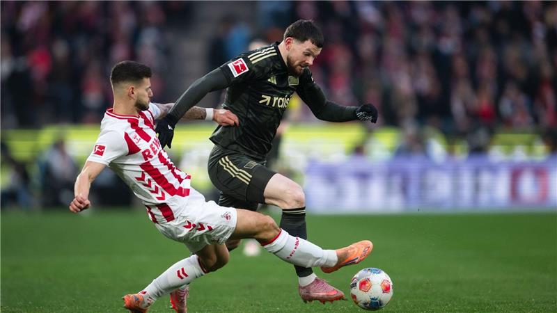 Kölns Tom Krauß (l) und Union Berlins Oliver Burke kämpfen um den Ball.